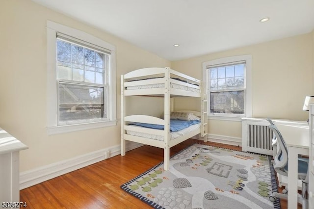 bedroom featuring hardwood / wood-style flooring and radiator