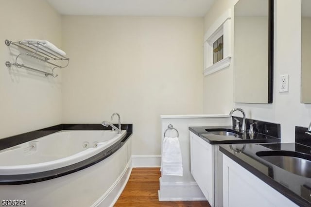 bathroom featuring a washtub, vanity, and hardwood / wood-style flooring