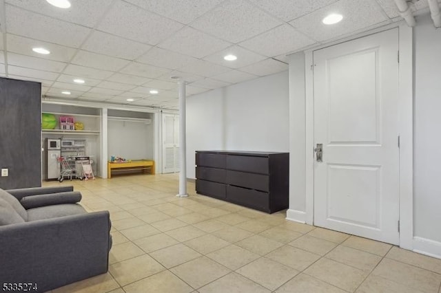 interior space featuring a drop ceiling and light tile patterned floors