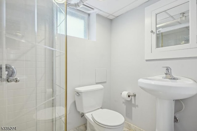 bathroom featuring toilet and a shower with shower door