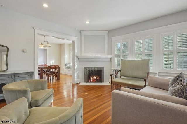 living room with hardwood / wood-style floors and a brick fireplace