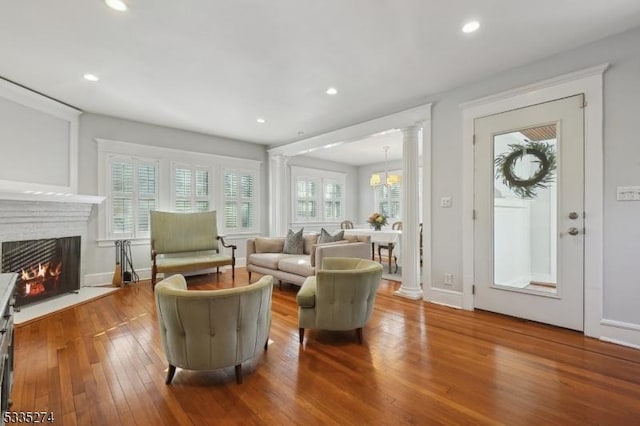 living room with decorative columns and wood-type flooring