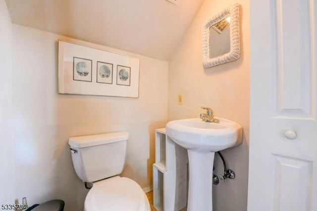 bathroom with lofted ceiling and toilet