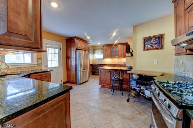 kitchen featuring dark stone countertops, sink, backsplash, and appliances with stainless steel finishes