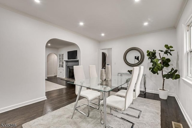 dining room with ornamental molding and dark hardwood / wood-style flooring