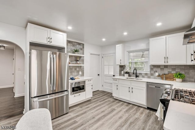 kitchen featuring white cabinetry, sink, backsplash, and appliances with stainless steel finishes