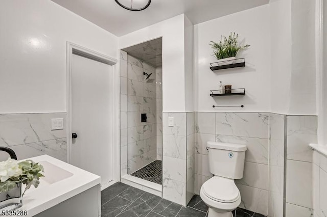 bathroom featuring vanity, tiled shower, tile walls, and toilet