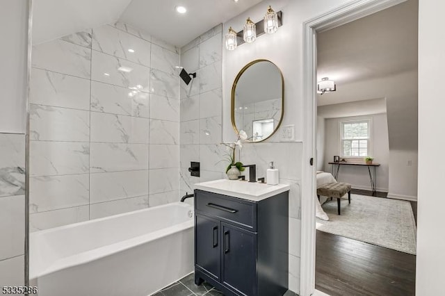 bathroom featuring tiled shower / bath, wood-type flooring, and vanity