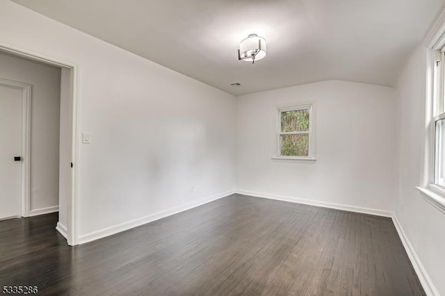 empty room featuring dark hardwood / wood-style flooring and lofted ceiling