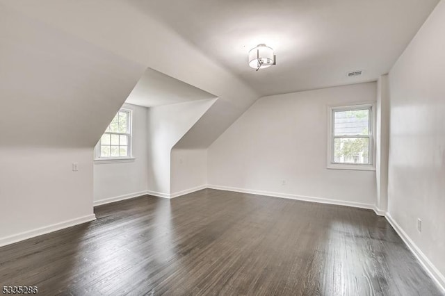 bonus room with lofted ceiling and dark wood-type flooring