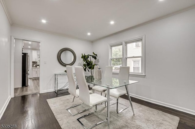 dining space with ornamental molding and dark hardwood / wood-style floors