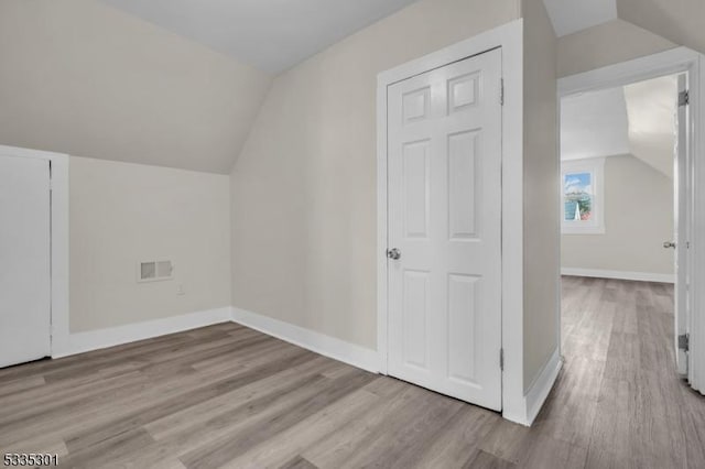 bonus room featuring vaulted ceiling and light hardwood / wood-style floors