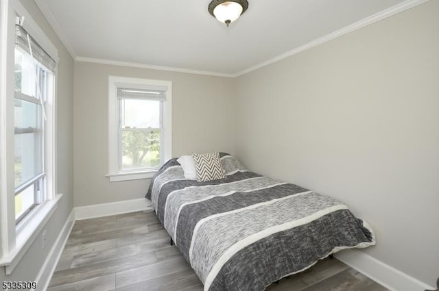 bedroom with hardwood / wood-style flooring and ornamental molding