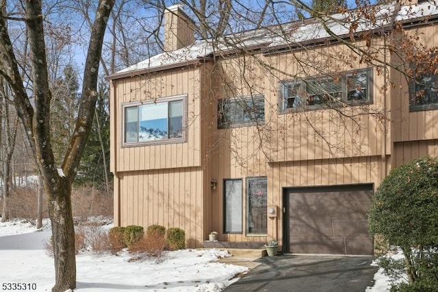 view of front facade with aphalt driveway and an attached garage