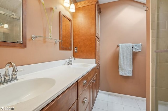 bathroom with double vanity, a sink, baseboards, and tile patterned floors