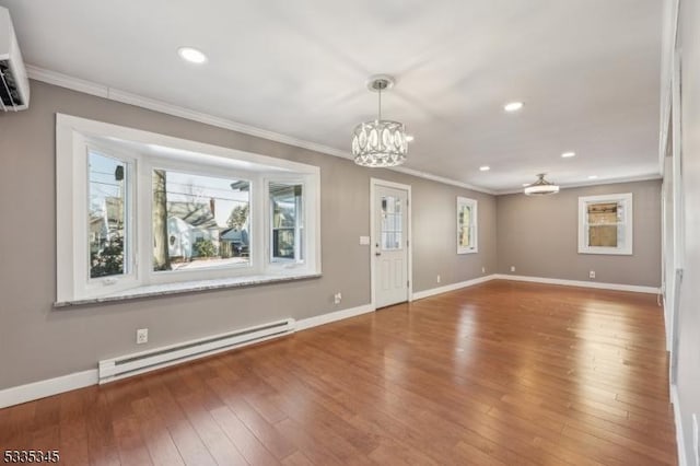 unfurnished living room featuring crown molding, a baseboard heating unit, a wall mounted AC, wood-type flooring, and a chandelier