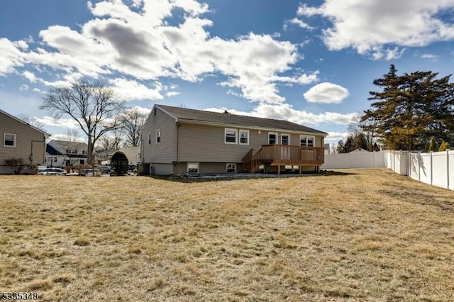 rear view of property featuring a yard and a wooden deck