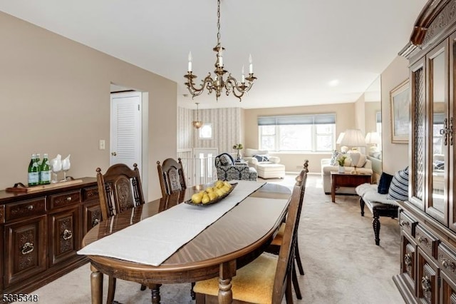 carpeted dining area featuring a notable chandelier