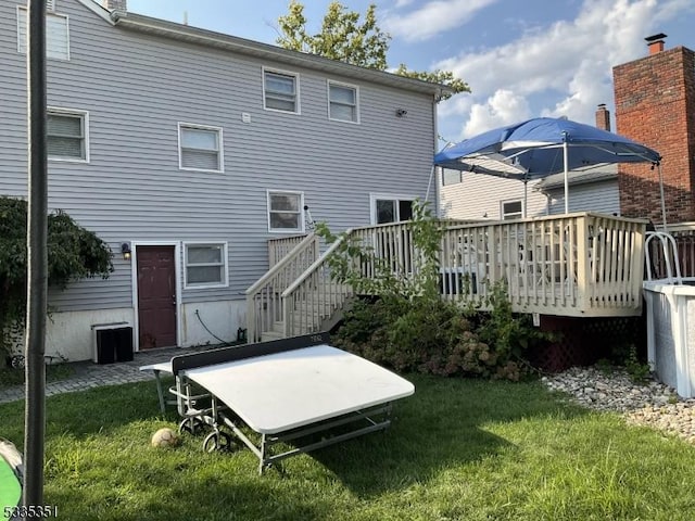 rear view of house with a yard and a deck