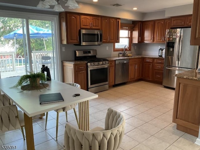 kitchen with stainless steel appliances, sink, and light tile patterned floors