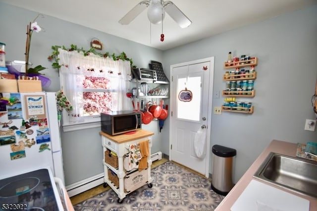 interior space featuring a healthy amount of sunlight, white fridge, sink, and baseboard heating