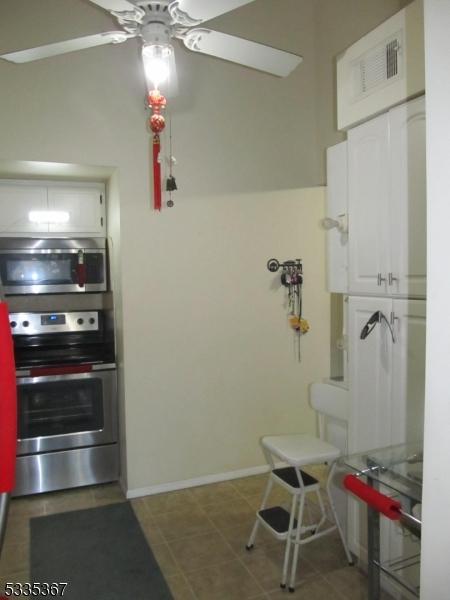 kitchen featuring ceiling fan, appliances with stainless steel finishes, tile patterned floors, and white cabinets