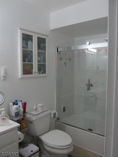 full bathroom featuring vanity, shower / bath combination with glass door, and toilet