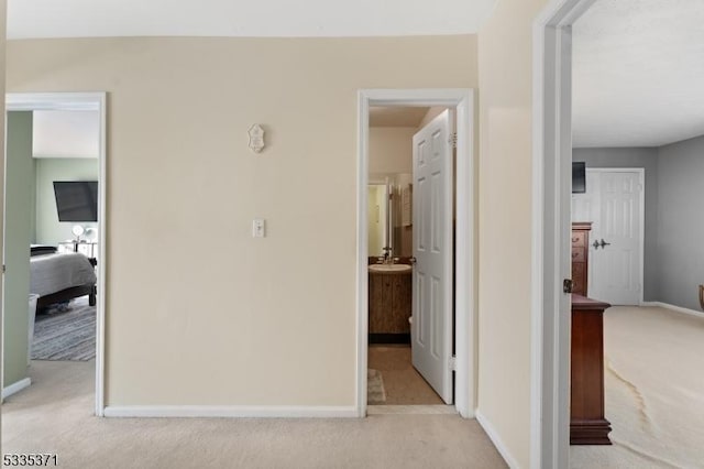 hallway featuring light colored carpet