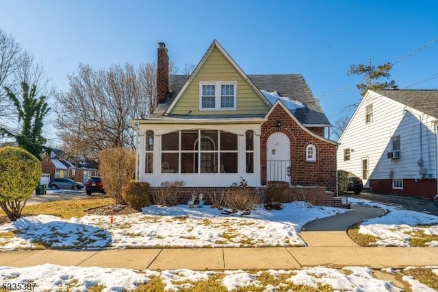 tudor-style house featuring a sunroom