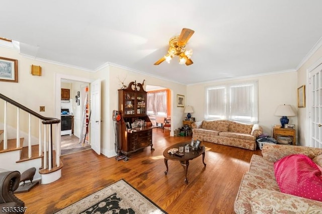 living room featuring hardwood / wood-style flooring, crown molding, and ceiling fan