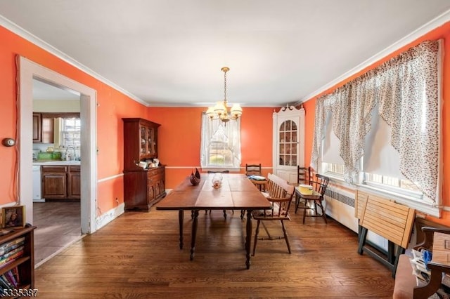 dining space with an inviting chandelier, crown molding, and dark hardwood / wood-style floors