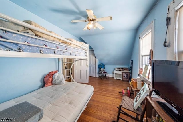 bedroom featuring dark hardwood / wood-style flooring, lofted ceiling, and ceiling fan