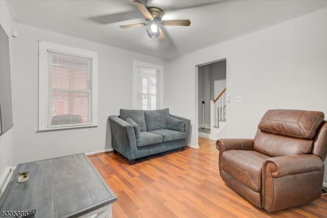 living room with light hardwood / wood-style floors and ceiling fan