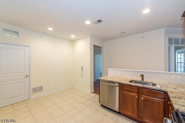 kitchen featuring light stone counters, dishwasher, sink, and decorative backsplash