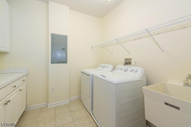 laundry room featuring sink, cabinets, light tile patterned floors, electric panel, and washer and clothes dryer