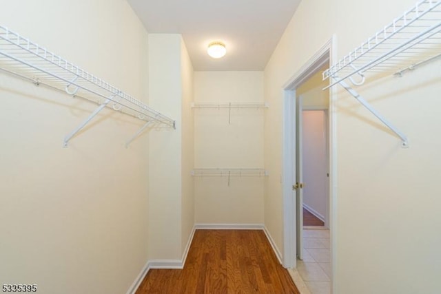 walk in closet with hardwood / wood-style floors