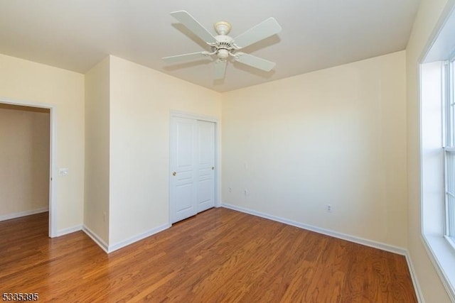 unfurnished bedroom with wood-type flooring, a closet, and ceiling fan