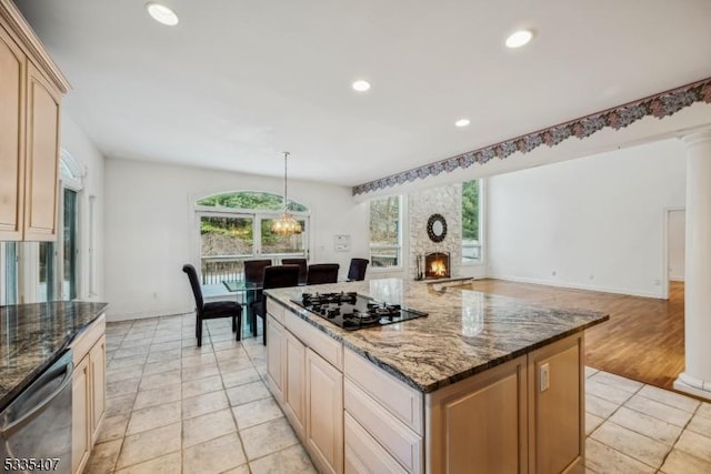 kitchen with stainless steel dishwasher, black gas cooktop, dark stone counters, and a center island