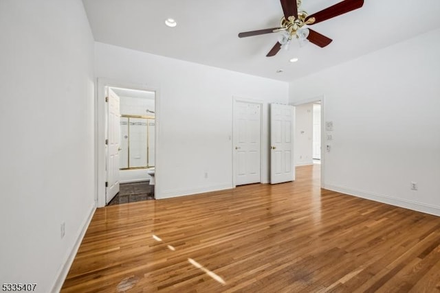 unfurnished bedroom with connected bathroom, hardwood / wood-style floors, and ceiling fan