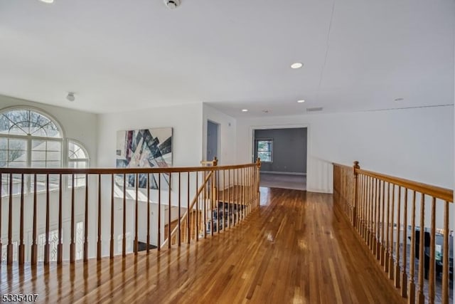 corridor with wood-type flooring and a wealth of natural light