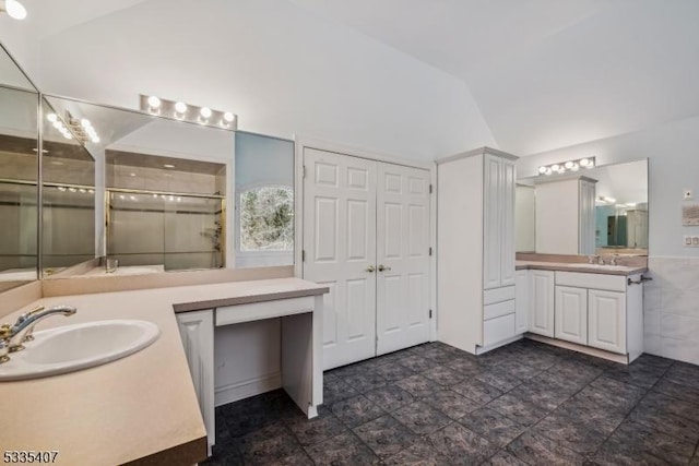 bathroom featuring vanity, lofted ceiling, tile walls, and an enclosed shower