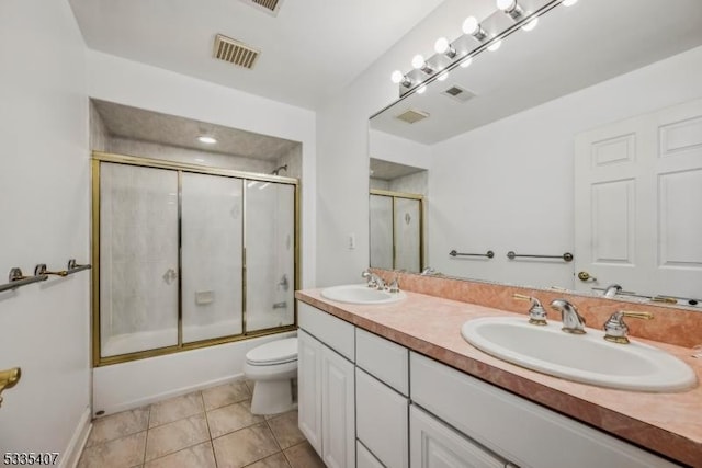 full bathroom featuring toilet, vanity, shower / bath combination with glass door, and tile patterned flooring