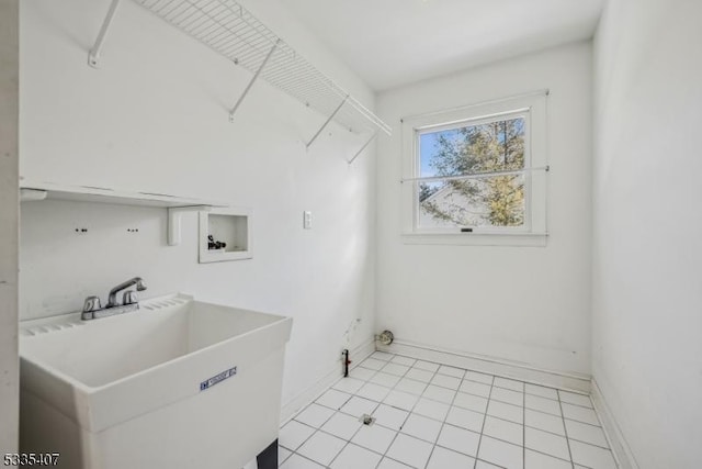 clothes washing area featuring sink, hookup for a washing machine, and light tile patterned floors