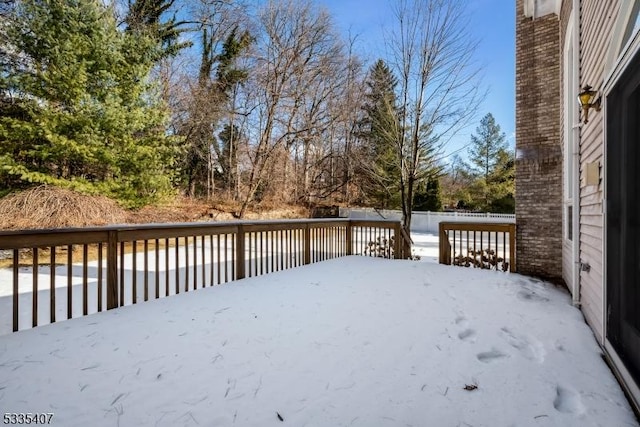 yard covered in snow with a deck