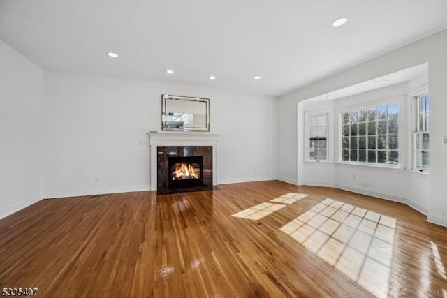 unfurnished living room featuring light hardwood / wood-style flooring and a premium fireplace