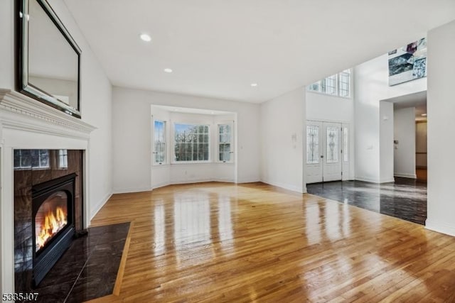 living room featuring hardwood / wood-style floors, a wealth of natural light, and a premium fireplace