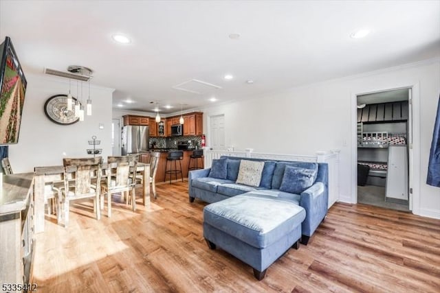 living room with ornamental molding and light hardwood / wood-style floors