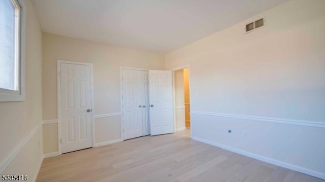 unfurnished bedroom with light hardwood / wood-style floors and a closet