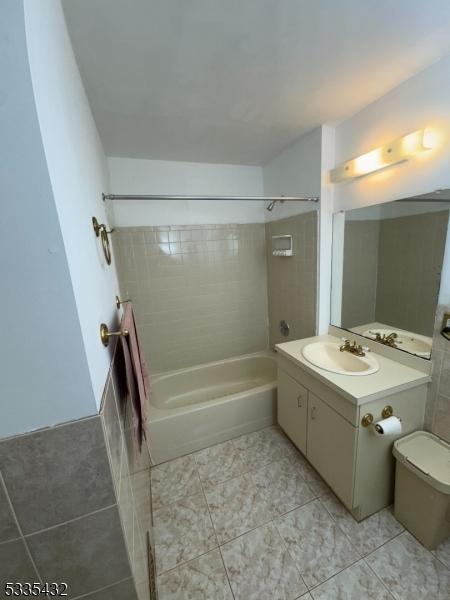 full bathroom with vanity, toilet, tiled shower / bath combo, and tile patterned flooring