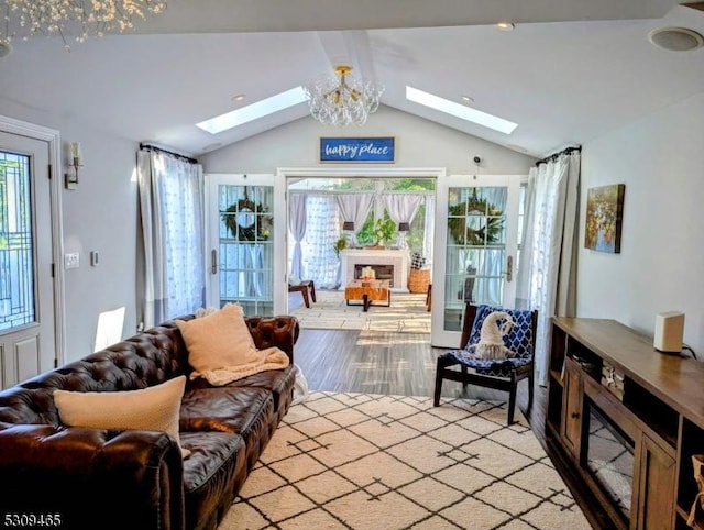 living room featuring lofted ceiling with skylight, an inviting chandelier, and light wood-type flooring